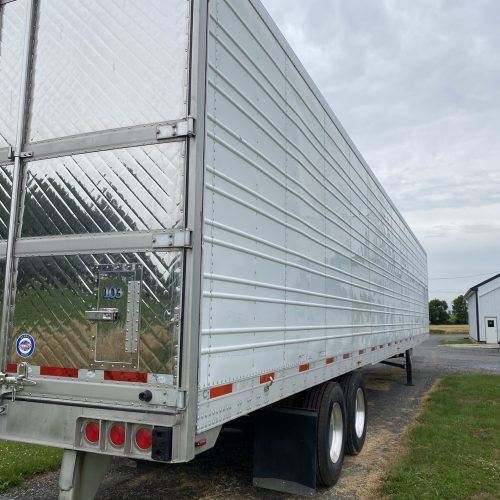 A trailer with a big metal roof sitting outdoors.