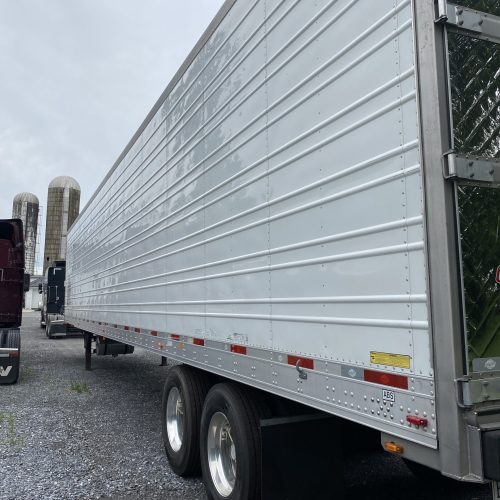 White trailer with flatbed, ready for transporting goods.