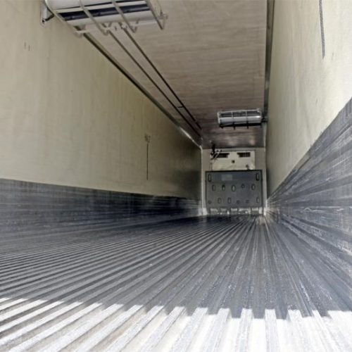 A long metal hallway with a door on the side.