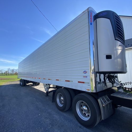 Semi truck and trailer parked on roadside.