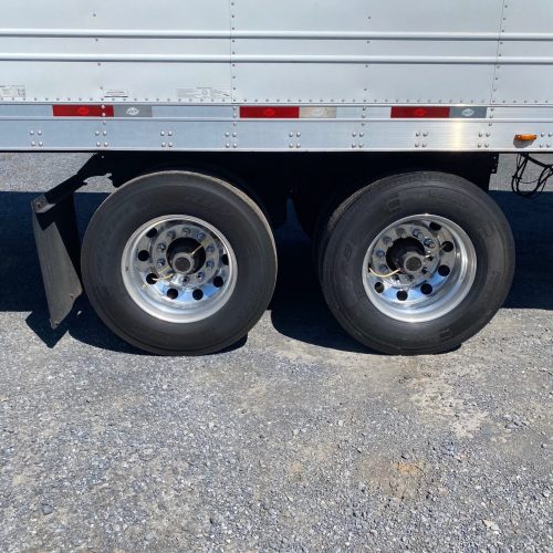 Rear tires of semi truck parked in lot.